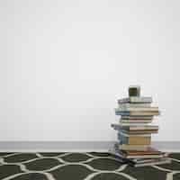 PSD gratuito libros apilados en el piso al lado de la pared blanca con copyspace