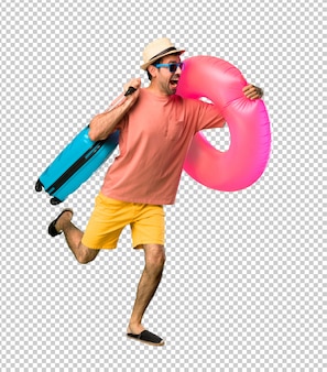 Man met hoed en zonnebril op zijn zomervakantie loopt snel