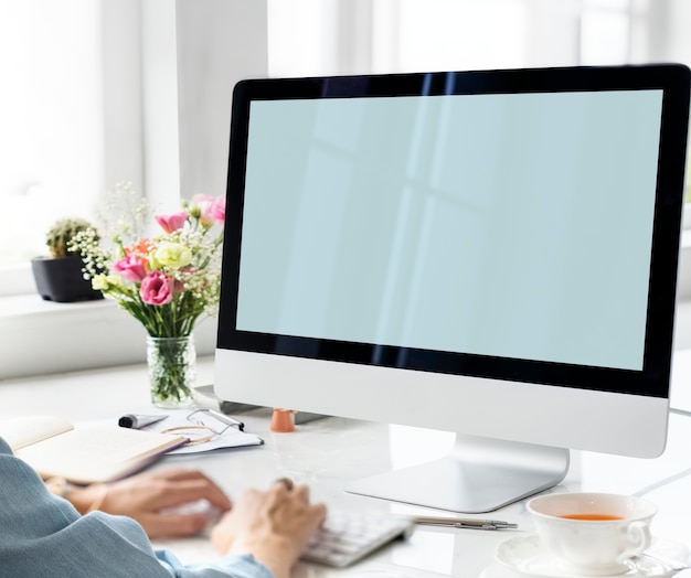 Manos escribiendo con una pantalla de computadora maqueta