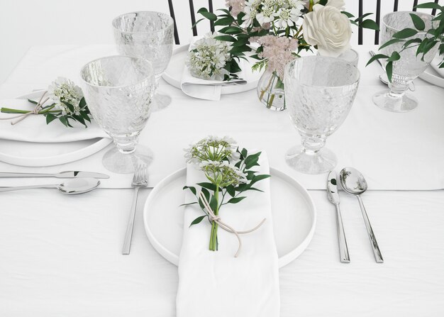 mesa preparada para comer con cubiertos y flores decorativas