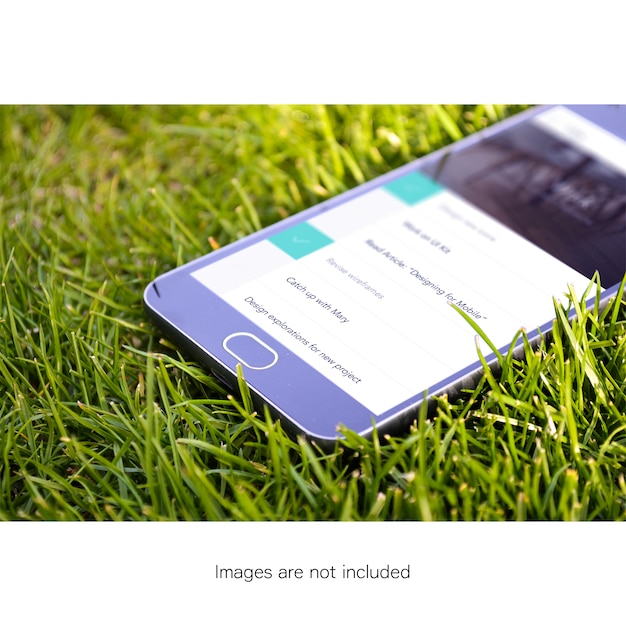 Gratis PSD mobiele telefoon scherm op gras mock up