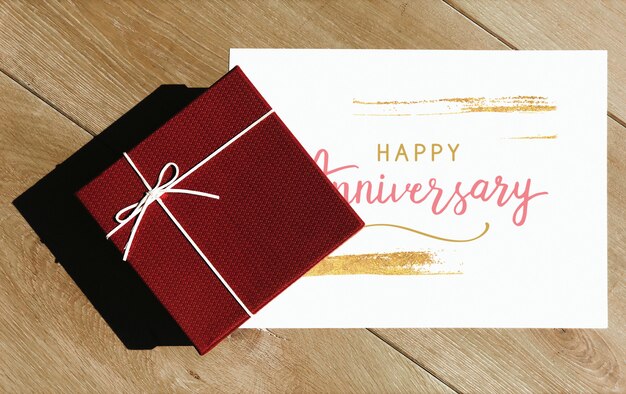 Mockup di carta di anniversario felice con una scatola regalo