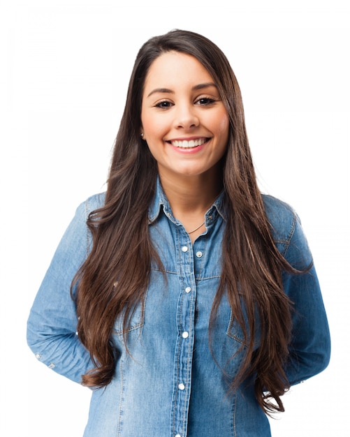 Mujer joven sonriente con las manos en su espalda