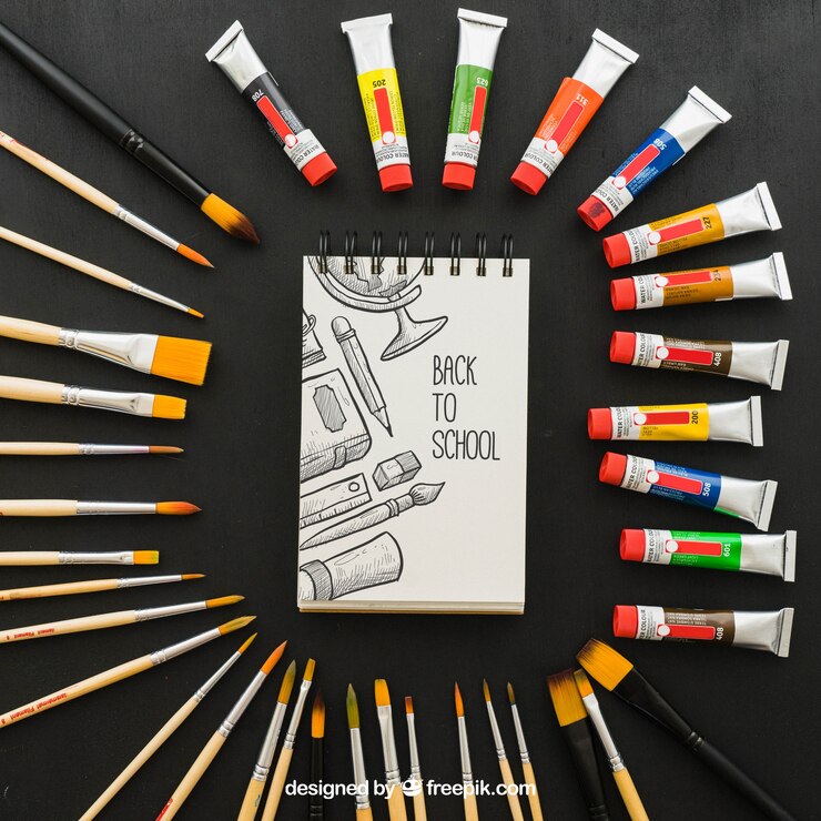 PSD Gratis paint and brushes around the notebook