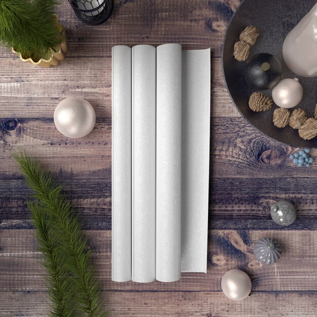 Papel en blanco sobre mesa de madera rodeada de adornos y pinos