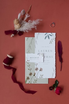Plat leggen van mock-up rustieke papieren huwelijksuitnodiging met bladeren en bloemen
