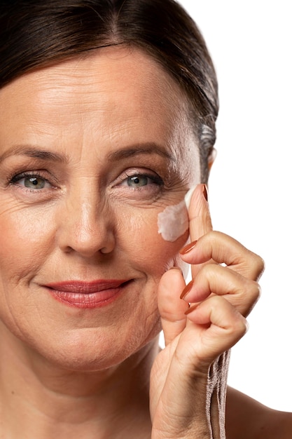 Portret van senior vrouw met vochtinbrengende crème