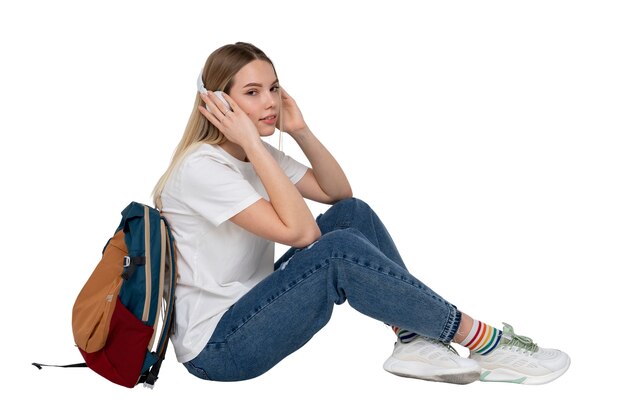 Retrato de estudio de una joven estudiante adolescente con mochila y auriculares