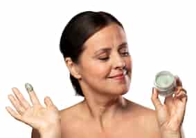 PSD gratuito retrato de mujer mayor con producto cosmético para el cuidado de la piel