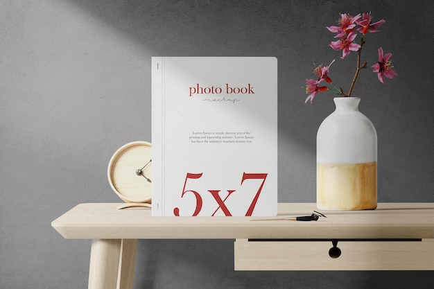 Schoon minimaal fotoboek 5x7 mockup op tafel met vaas en klok
