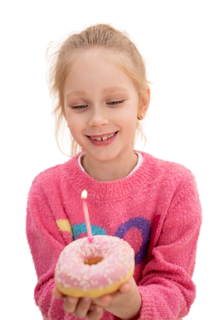 Studioportret van jong meisje met verjaardagsdoughnut