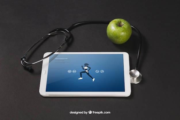 PSD gratuito tablet con una app de deportes, una manzana y un estetoscopio