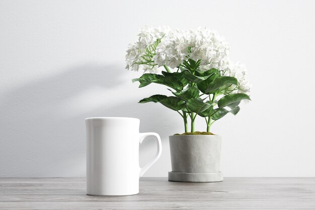 taza de cerámica y flor dentro de maceta