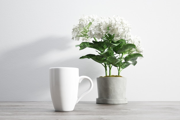 Taza de cerámica y flor dentro de maceta