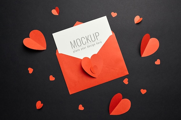 Valentijnsdag kaart mockup met rode envelop en harten op zwart papier
