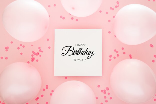 Fond d'anniversaire avec des confettis roses et des ballons