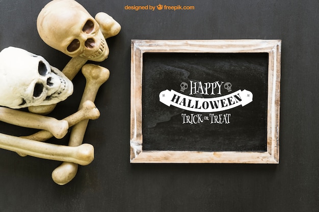 Maquette de l&#39;ardoise de Halloween avec deux crânes et des os