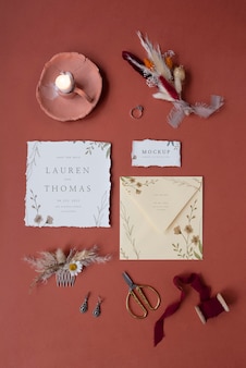 Mise à plat d'une maquette d'invitation de mariage en papier rustique avec des feuilles et des fleurs