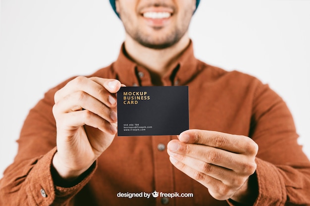 PSD gratuit mock up avec le jeune homme et la carte de visite au premier plan