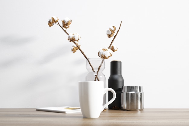 tasse en céramique et plante de coton à l'intérieur du pot de fleurs