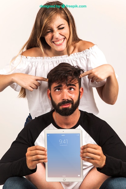 Casal engraçado que apresenta o tablet