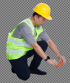 Comprimento total do 50s 60s homem idoso asiático engenheiro usa colete de segurança ferramentas de capacete, nível de equilíbrio. vista traseira do lado posterior masculino sênior sentado e linha de equilíbrio com equipamento de nível de bolha sobre branco isolado