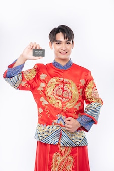 Homem chinês segurando modelo de cartão de crédito em branco