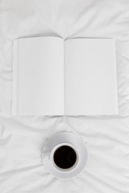 Livro vazio com vista superior e xícara de café Psd Premium