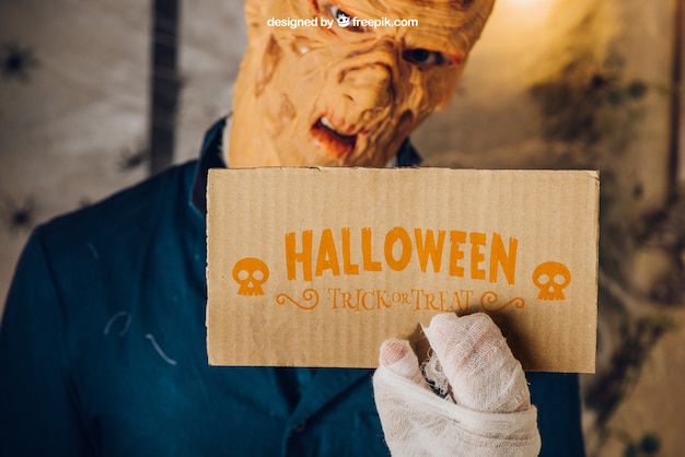 Maquete de Halloween com zumbi segurando cartão