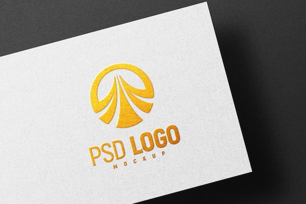 Maquete de logotipo dourado em relevo em papel branco