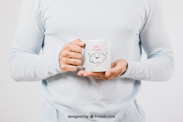Mock up design com as mãos segurando uma caneca de café