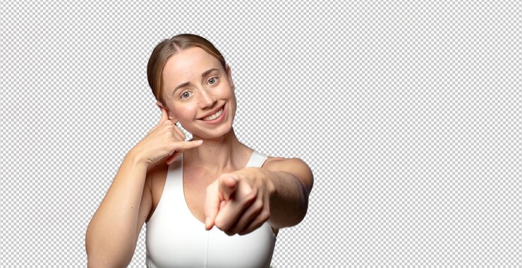PSD grátis mulher loira sorrindo alegremente e apontando para a câmera enquanto faz uma chamada você mais tarde gesto falando no telefone