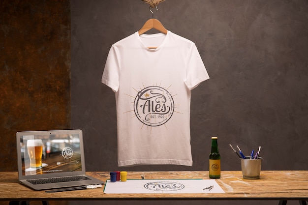 T-shirt branca vista frontal com laptop e cerveja Psd Premium