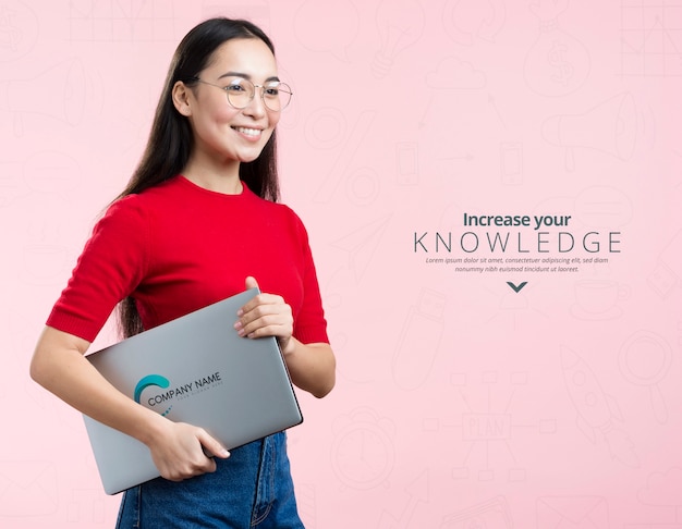 Vista frontal mulher segurando um laptop e um anúncio de mock-up