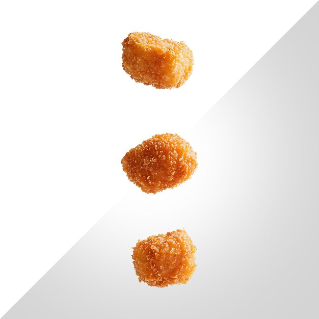 3 pepitas de pollo fritas cubiertas con 3 colores diferentes en un fondo transparente