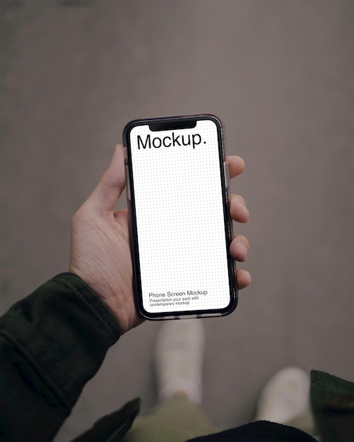 A person holding a phone with screen mockup