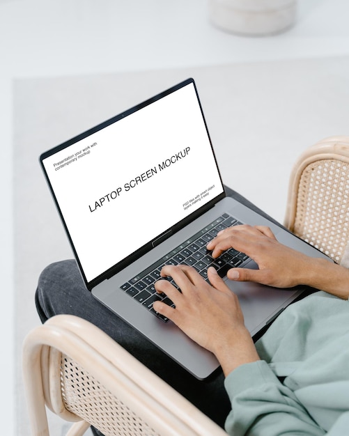 A pessoa está digitando em um laptop com maquete de tela