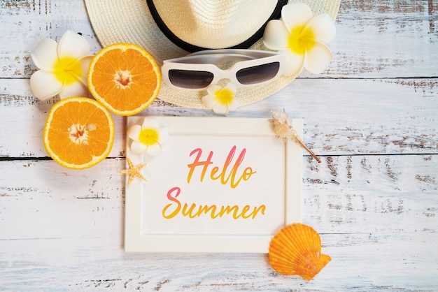 Accesorios de playa, naranja, gafas de sol, sombrero y conchas.