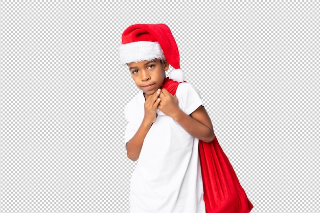 Afro-américain Garçon Avec Un Chapeau De Noël Et Prenant Un Sac Avec Des Cadeaux