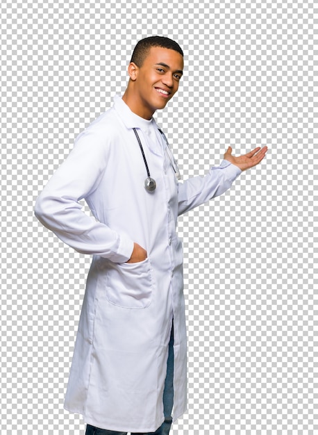 Afro americano homem jovem médico apontando para trás e apresentando um produto