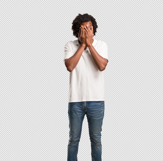El afroamericano guapo se siente preocupado y asustado, mirando y cubriendo la cara, el concepto de miedo y ansiedad