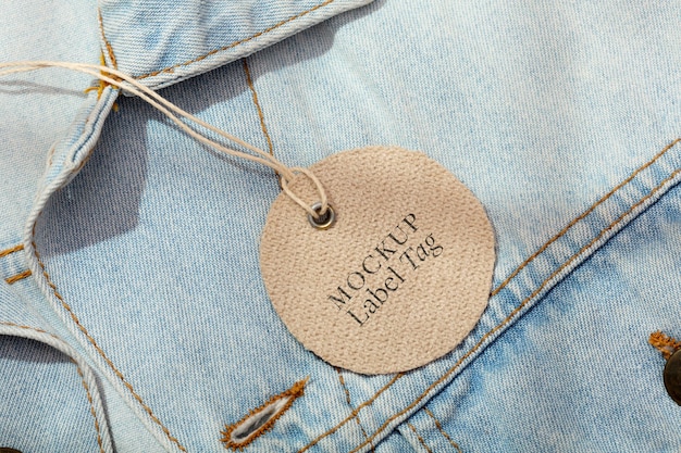 Alto ângulo de etiqueta de roupas na jaqueta jeans