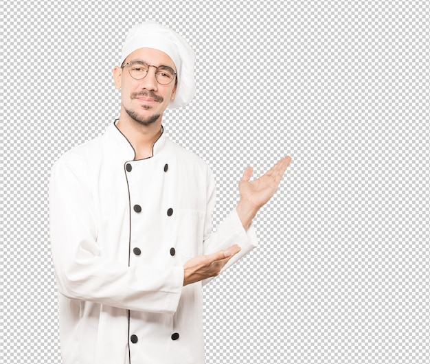 Amable joven chef haciendo un gesto de bienvenida