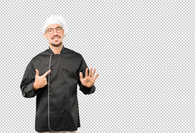 Amable joven chef haciendo un gesto de calma
