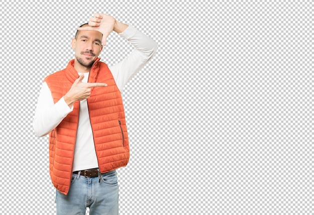 Amable joven haciendo un gesto de tomar una foto con las manos