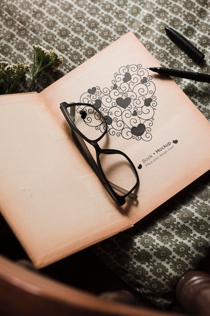 Angle élevé du livre avec des lunettes et un stylo