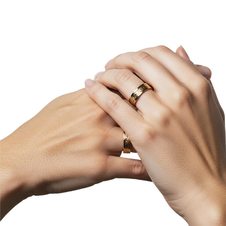 Anillos de pareja grabados en oro aislados sobre un fondo transparente