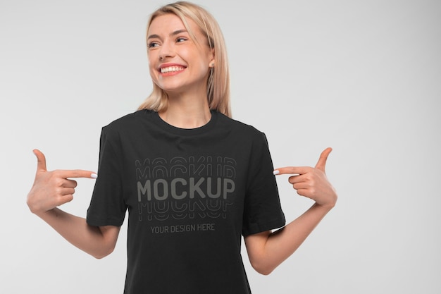 Ansicht einer Frau, die ein T-Shirt-Attrappe-Design trägt und darauf zeigt