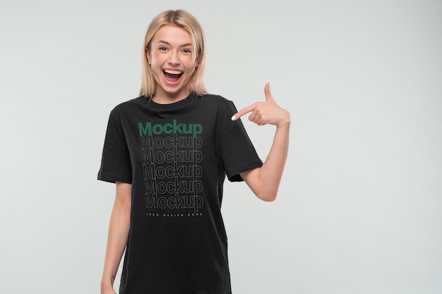 Ansicht einer Frau, die ein T-Shirt-Attrappe-Design trägt und darauf zeigt