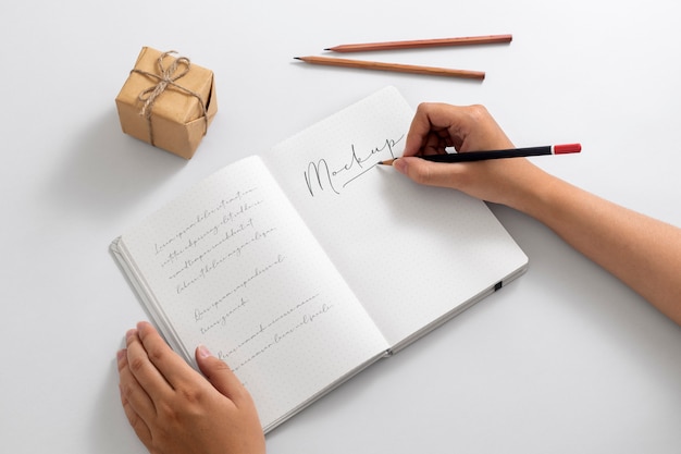 Ansicht einer Person, die mit Bleistift auf Papier schreibt